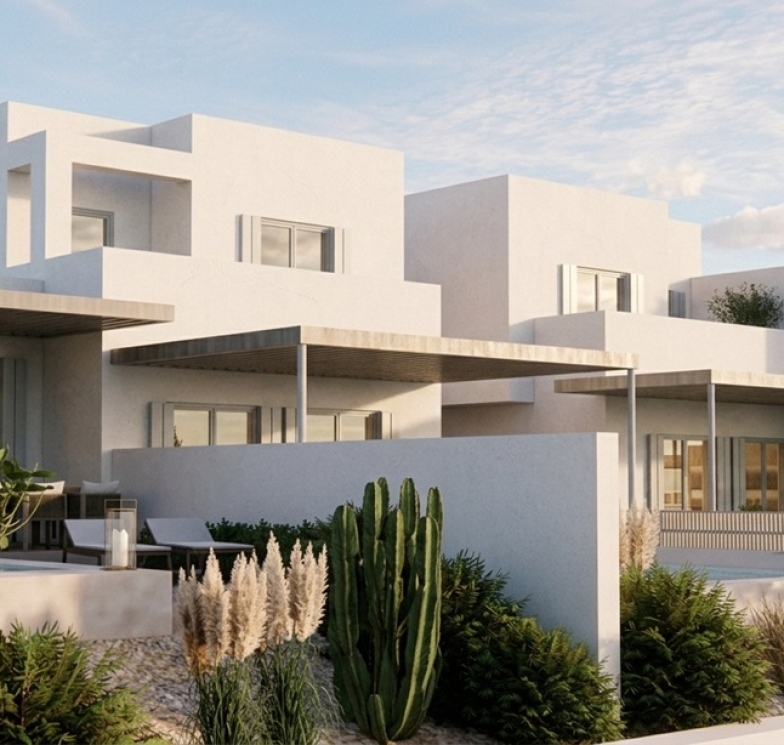 Partial side view of a few Cycladic summer villas in a complex in Syros with whitewashed cubic structures, wooden pergolas and small private pools. Image copyright: Karydis and Associates.